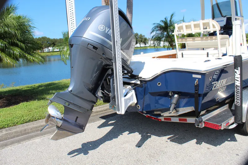 Slide: The Image of 2017 Pathfinder 2500 Hybrid boat with Yamaha outboard motor, parked near a scenic lake. - 13