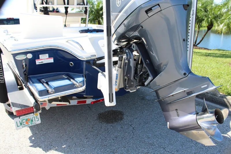 Slide: The Image of 2017 Pathfinder 2500 Hybrid boat with outboard motor and trailer, parked near water. - 14