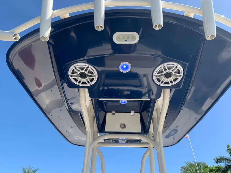 Slide: The Image of 2017 Pathfinder 2500 Hybrid boat T-top with speakers and rod holders against blue sky. - 24