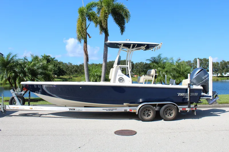 Slide: The Image of 2017 Pathfinder 2500 Hybrid boat on trailer, parked near palm trees and water. - 4