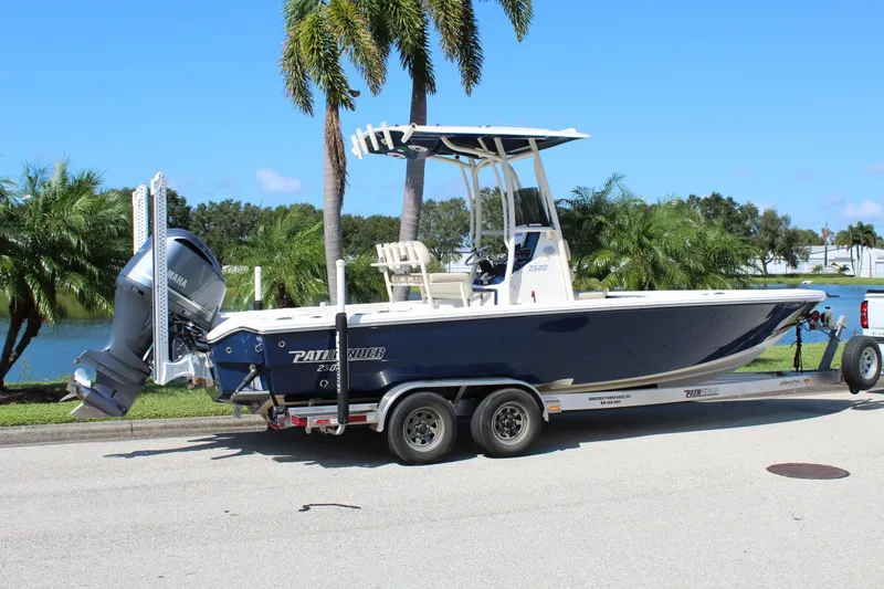 Slide: The Image of 2017 Pathfinder 2500 Hybrid boat on trailer, parked near palm trees and water. - 7