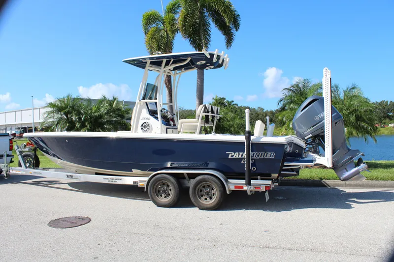 Slide: The Image of 2017 Pathfinder 2500 Hybrid boat on trailer, parked near palm trees and water. - 8