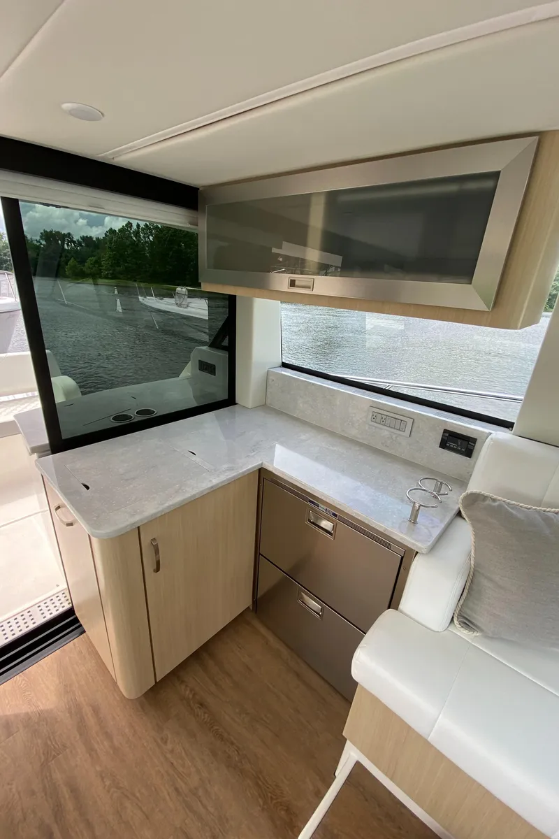 Slide: The Image of Modern kitchen area in 2024 Regal 38XO yacht with sleek cabinetry and large windows. - 11