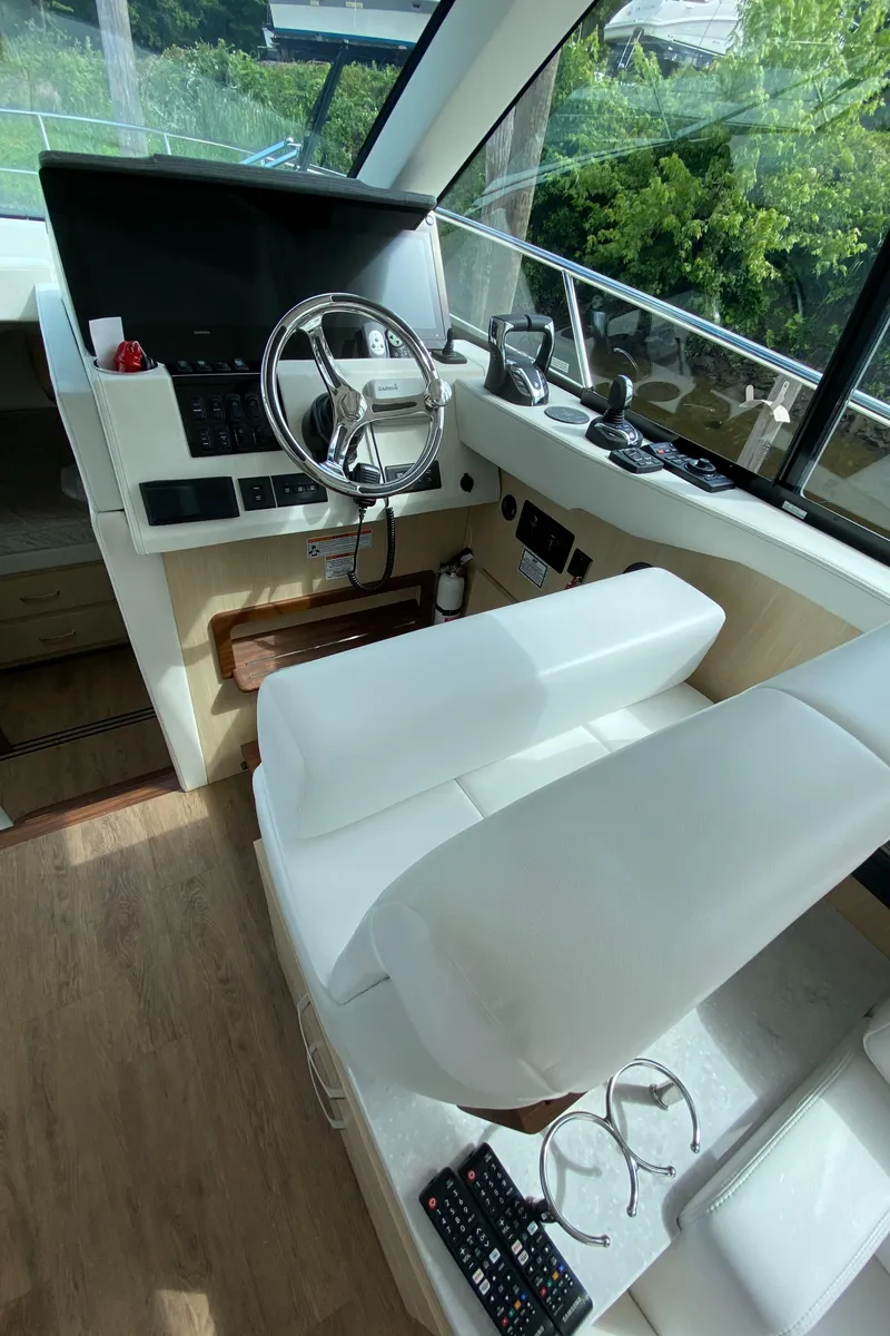 Slide: The Image of 2024 Regal 38XO yacht cockpit with modern controls and white seating. - 12