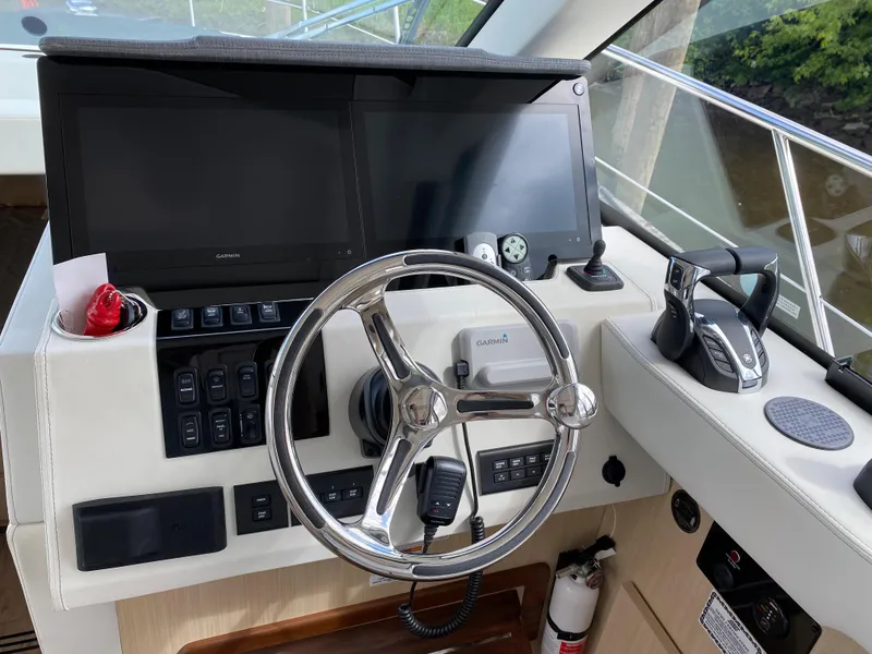 Slide: The Image of 2024 Regal 38XO boat helm with dual screens and steering wheel. - 13