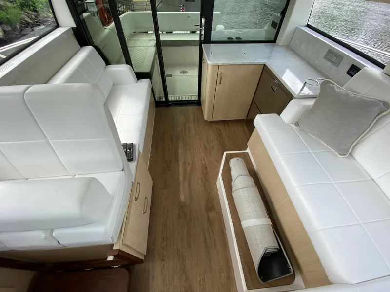 Slide: The Image of Interior of 2024 Regal 38XO yacht with white seating and wooden flooring. - 14