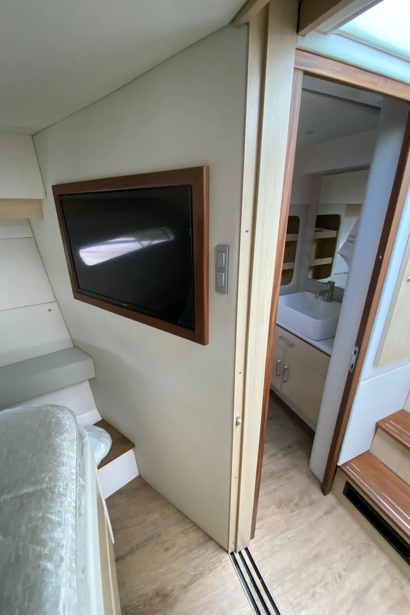 Slide: The Image of 2024 Regal 38XO yacht interior with TV and bathroom. - 17