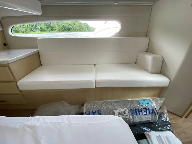 Slide: The Image of 2024 Regal 38XO yacht interior with white leather seating and scenic window view. - 22