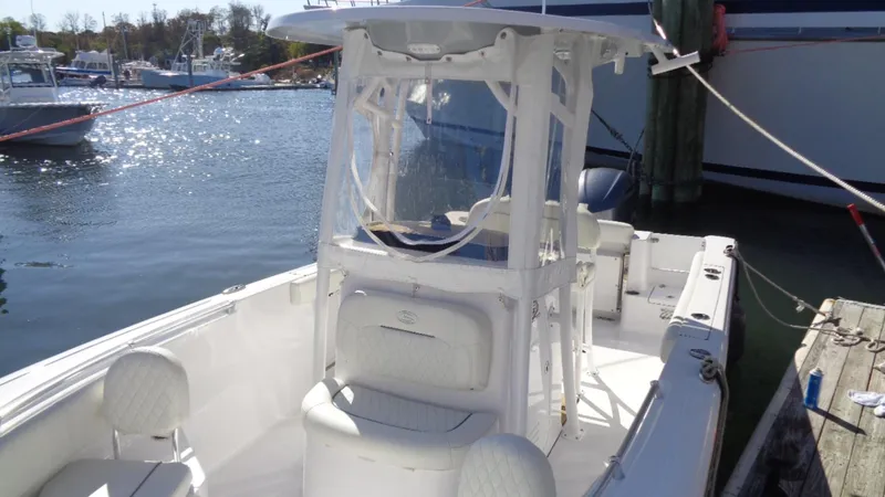 Slide: The Image of 2018 Sportsman 232 Open boat docked at marina, featuring center console and seating. - 3