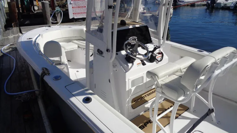 Slide: The Image of 2018 Sportsman 232 Open boat docked, featuring a sleek console and seating. - 5