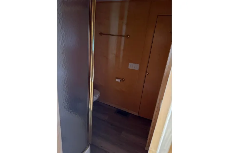 Slide: The Image of Bathroom interior of 2004 Stardust Cruisers San Juan Sunrise Trip 24, featuring shower and wooden walls. - 6