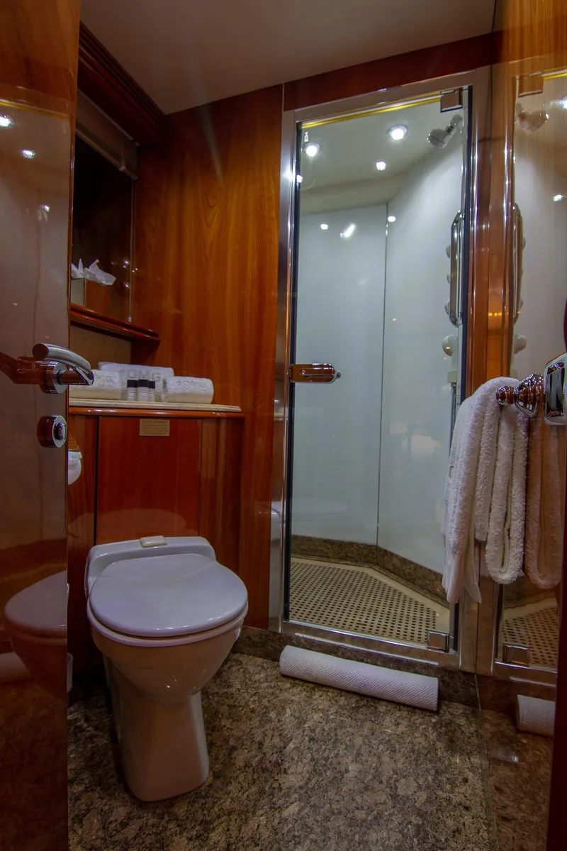 Slide: The Image of Luxurious bathroom on a 2002 Sunseeker 105 Yacht with wood paneling and glass shower. - 16