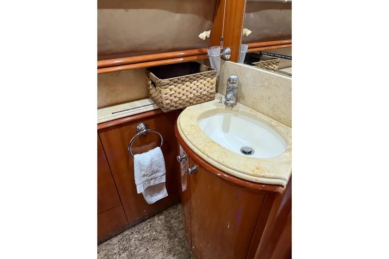 Slide: The Image of Luxurious bathroom sink area on a 2002 Sunseeker 105 Yacht, featuring elegant wood cabinetry. - 32