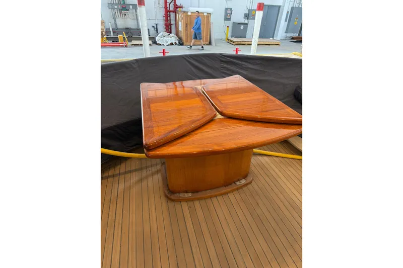Slide: The Image of Wooden table on Sunseeker 105 Yacht, 2002 model, in a maintenance area. - 46