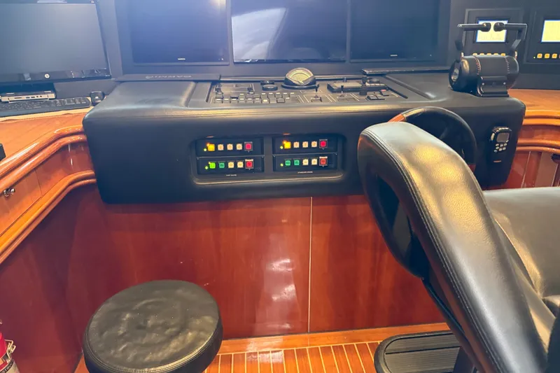 Slide: The Image of Control panel of a 2002 Sunseeker 105 Yacht with leather seating and wooden accents. - 49