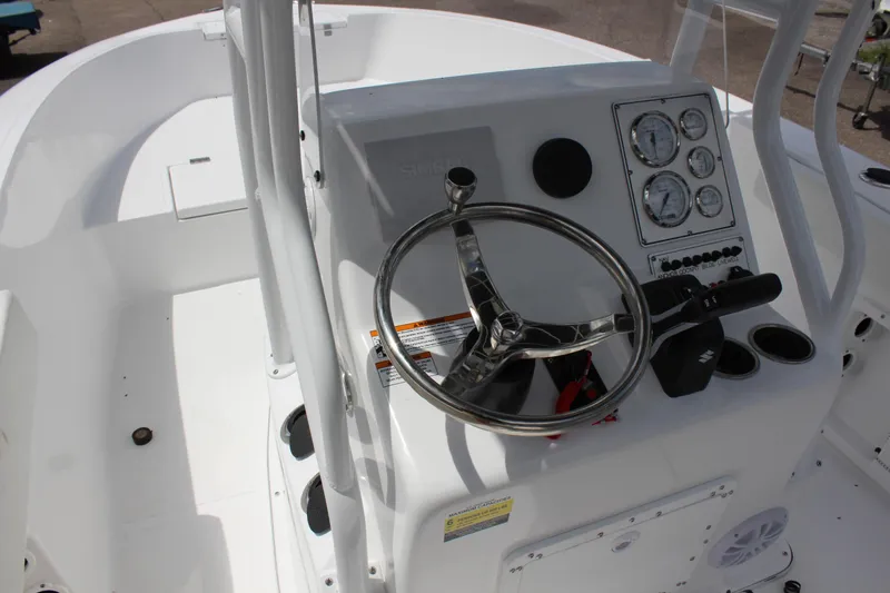 Slide: The Image of Clearwater 2000 CC 2024 boat console with steering wheel and gauges. - 12