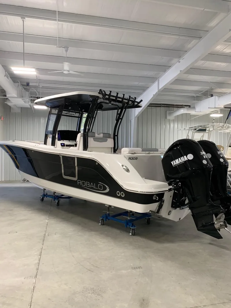 Slide: The Image of 2024 Robalo 302 boat with Yamaha engines in a storage facility. - 2