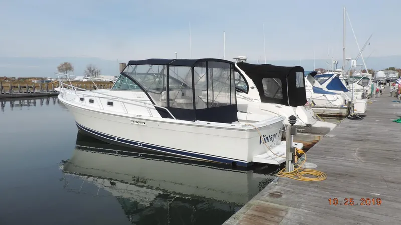 The Image of 1998 Mainship 30 PILOT boat docked at marina with protective canopy. - 1