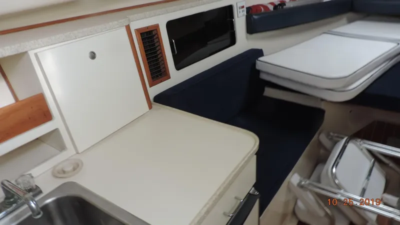 Slide: The Image of 1998 Mainship 30 PILOT interior with kitchenette, sink, and seating area. - 12