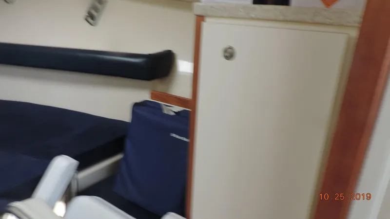 Slide: The Image of Interior cabin of 1998 Mainship 30 PILOT with blue seating and storage cabinet. - 13