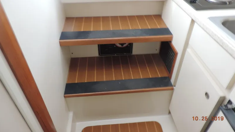 Slide: The Image of 1998 Mainship 30 PILOT interior stairs with wood finish and black accents. - 17