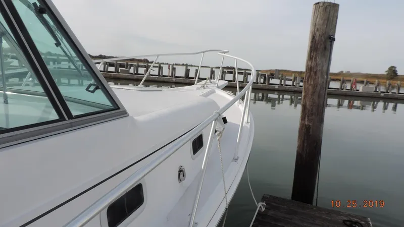 Slide: The Image of 1998 Mainship 30 PILOT boat docked at a marina, side view. - 3