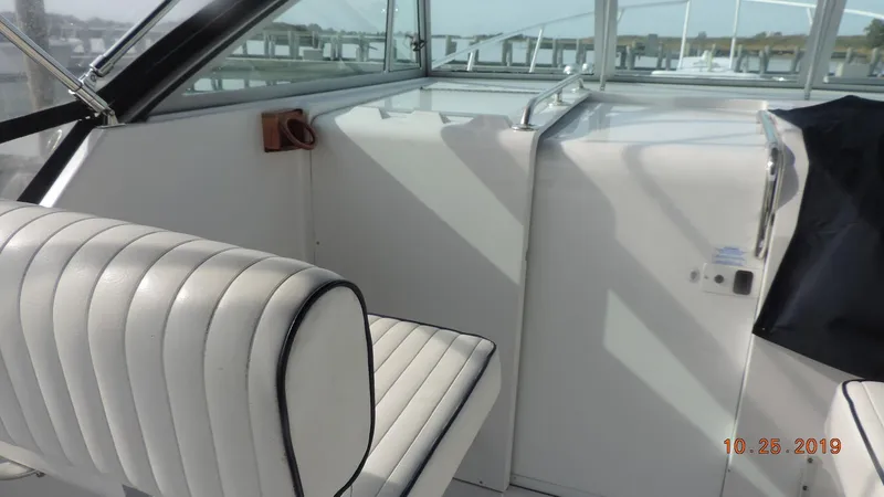 Slide: The Image of 1998 Mainship 30 PILOT interior with white seating and helm area. - 4