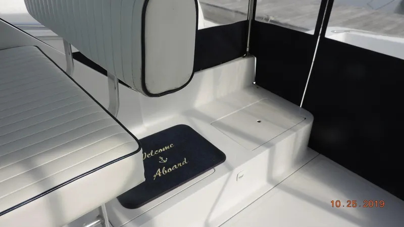 Slide: The Image of 1998 Mainship 30 PILOT interior with seating and "Welcome Aboard" mat. - 5