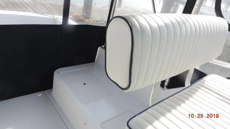 Slide: The Image of 1998 Mainship 30 PILOT boat interior with white cushioned seating. - 6