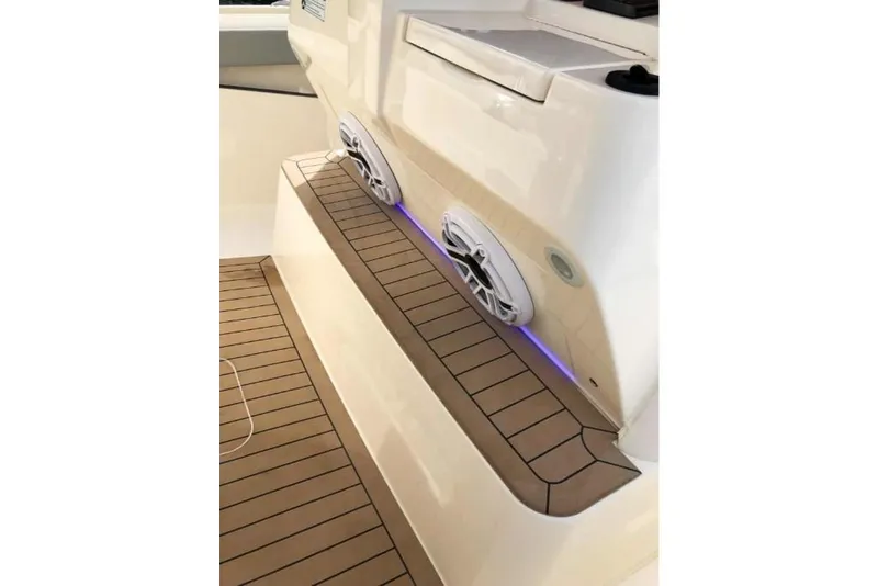Slide: The Image of 2023 Scout 330 LXF boat interior with teak flooring and built-in speakers. - 14