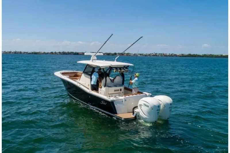 Slide: The Image of 2023 Scout 330 LXF boat cruising on open water. - 2