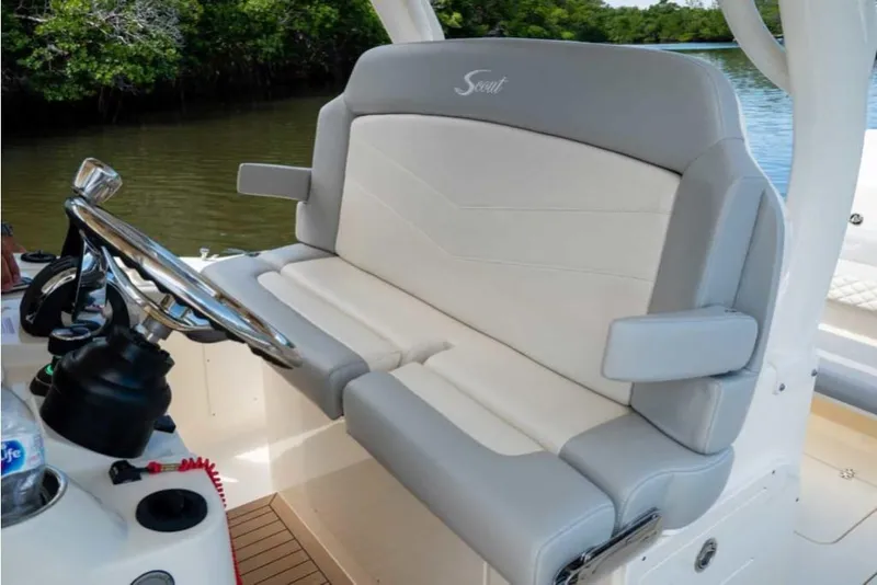 Slide: The Image of 2023 Scout 330 LXF boat helm seat with steering wheel and armrests. - 21