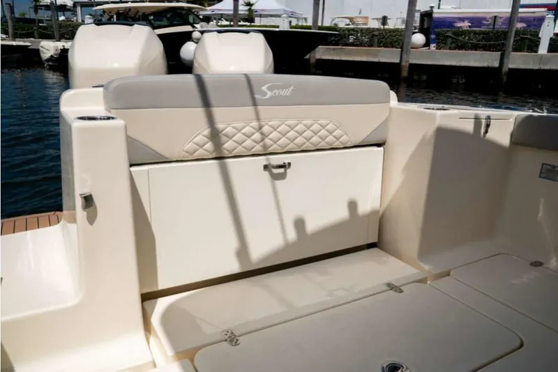 Slide: The Image of 2023 Scout 330 LXF boat interior with cushioned seating and storage compartment. - 26