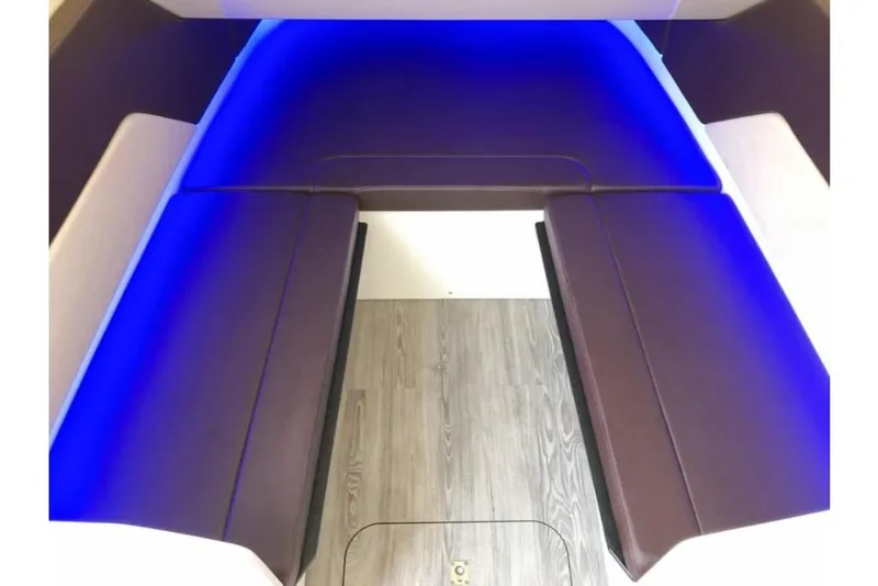 Slide: The Image of 2023 Scout 330 LXF boat interior with blue LED lighting and cushioned seating. - 28