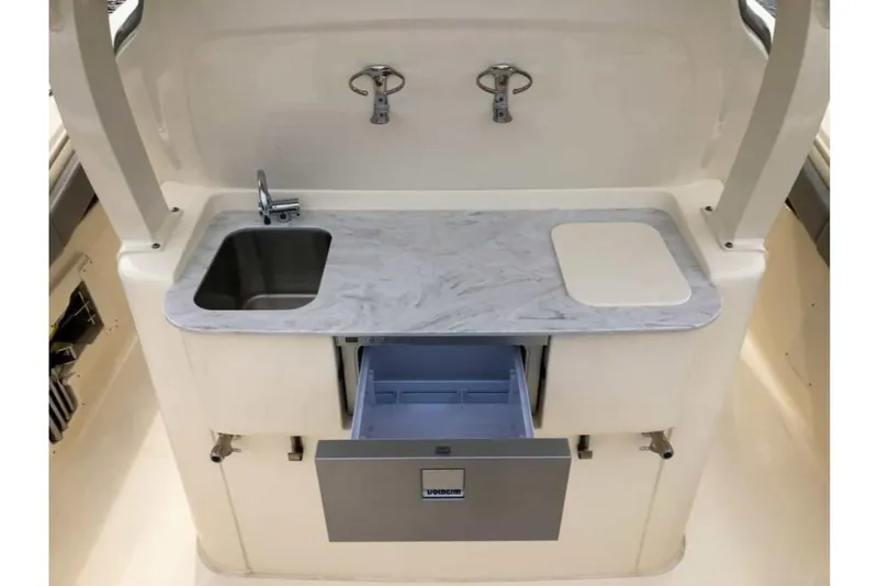 Slide: The Image of 2023 Scout 330 LXF boat galley with sink, countertop, and storage. - 32