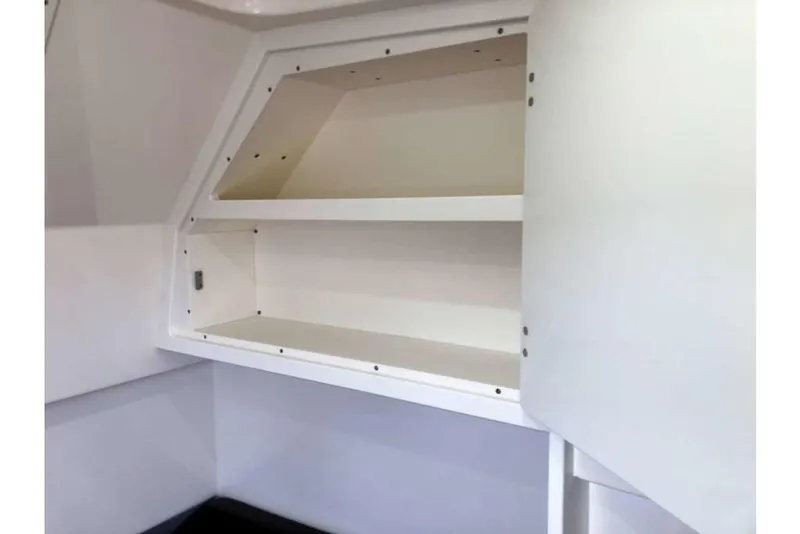 Slide: The Image of 2023 Scout 330 LXF boat interior storage compartment with open shelves. - 44