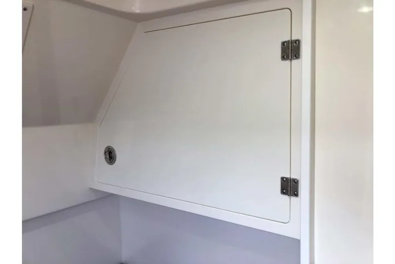 Slide: The Image of 2023 Scout 330 LXF storage compartment with white hinged door. - 45