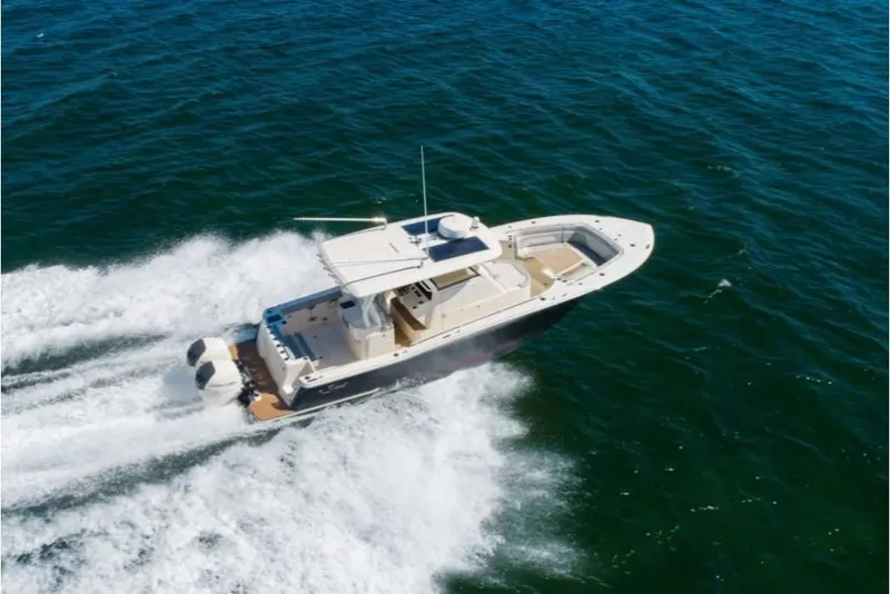Slide: The Image of 2023 Scout 330 LXF boat cruising on open water. - 6