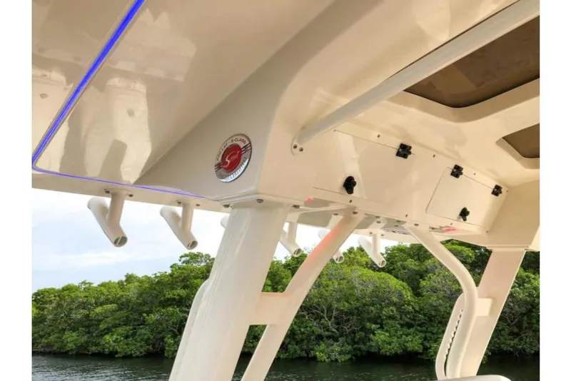 Slide: The Image of 2023 Scout 330 LXF boat interior with rod holders and storage compartments. - 8