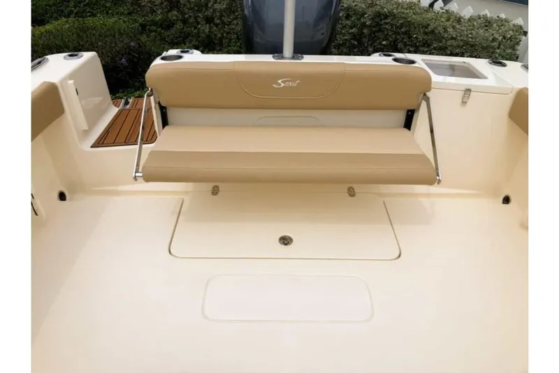 Slide: The Image of 2023 Scout 215 Dorado boat interior with beige seating and storage compartment. - 14