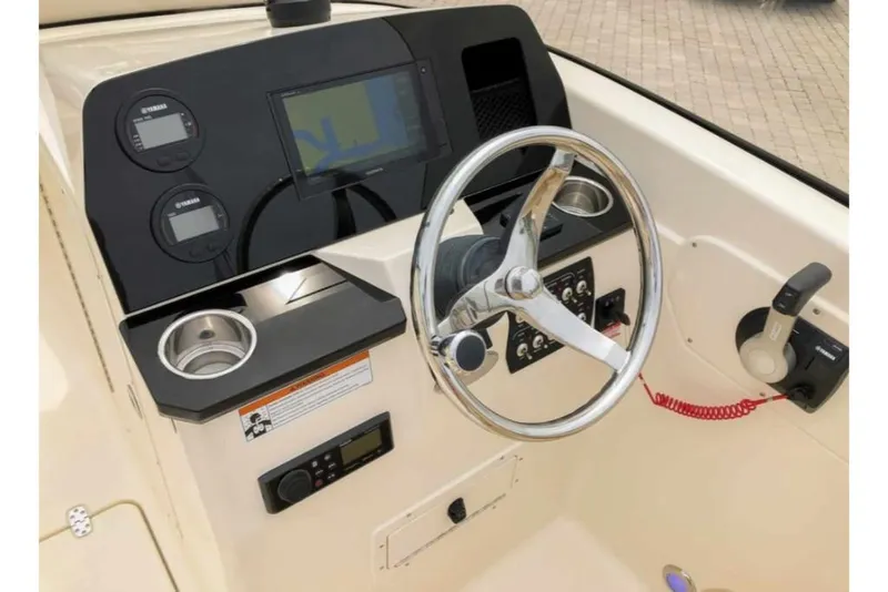 Slide: The Image of 2023 Scout 215 Dorado boat dashboard with steering wheel, gauges, and navigation system. - 21