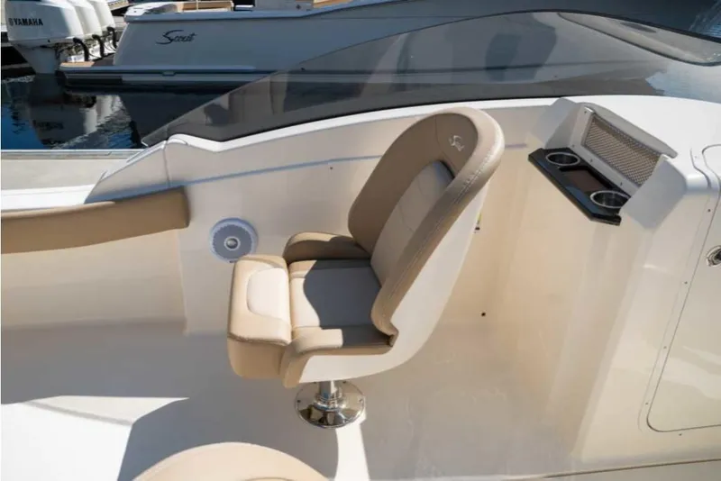 Slide: The Image of 2023 Scout 215 Dorado boat interior with beige captain's chair and cup holders. - 35