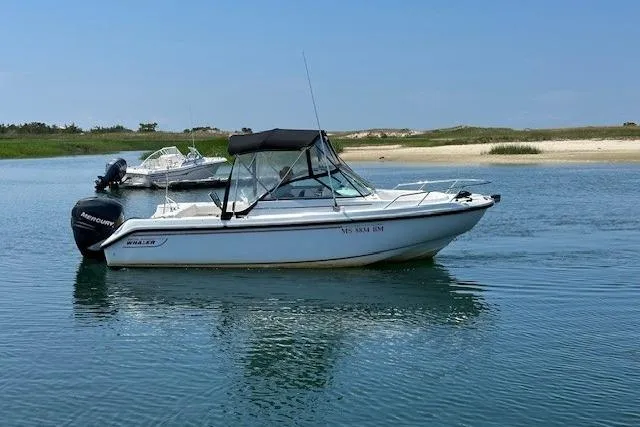 Slide: The Image of 2005 Boston Whaler VENTURA 210 boat on calm water, clear sky background. - 1