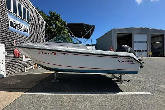 Slide: The Image of 2005 Boston Whaler VENTURA 210 boat on display outside a marine service building. - 10