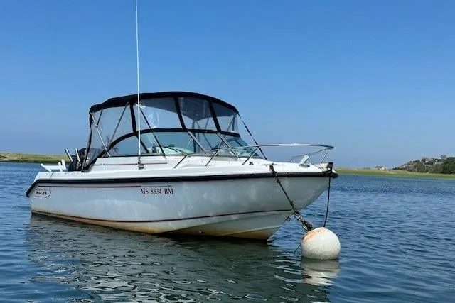 Slide: The Image of 2005 Boston Whaler VENTURA 210 boat anchored on calm water under clear blue sky. - 12