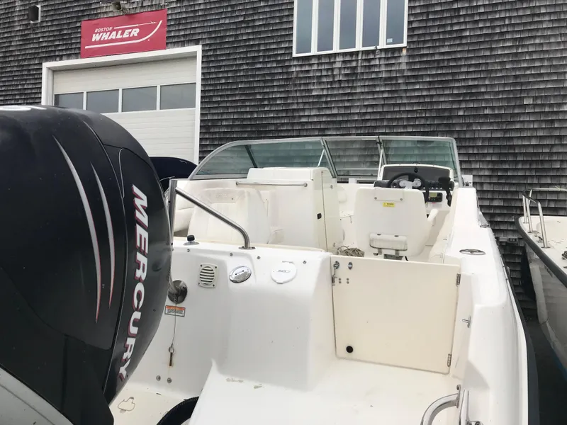 Slide: The Image of 2005 Boston Whaler VENTURA 210 boat with Mercury engine, outside warehouse. - 6