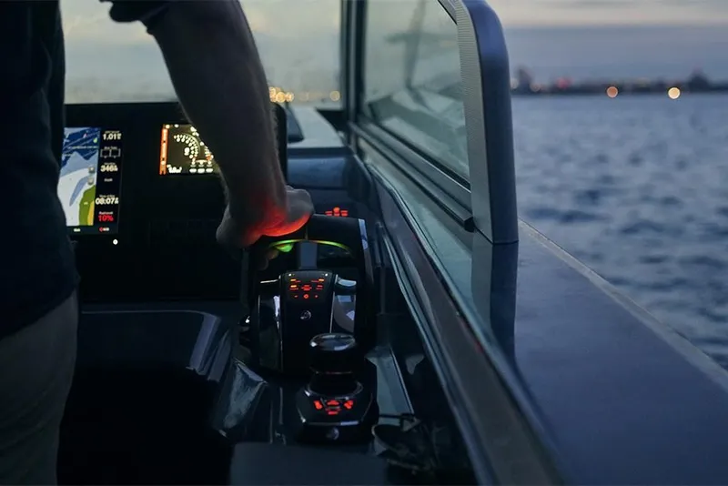 Slide: The Image of 2023 Aviara AV36 boat cockpit at dusk, with illuminated controls and water view. - 10