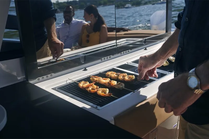 Slide: The Image of Grilling shrimp on a 2023 Aviara AV36 boat with friends in the background. - 14
