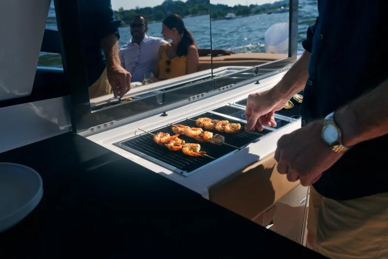 Slide: The Image of Grilling on a 2023 Aviara AV36 boat with friends in the background. - 26