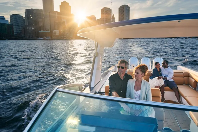 Slide: The Image of Couples enjoying a sunset cruise on a 2023 Aviara AV36 boat with city skyline in the background. - 5